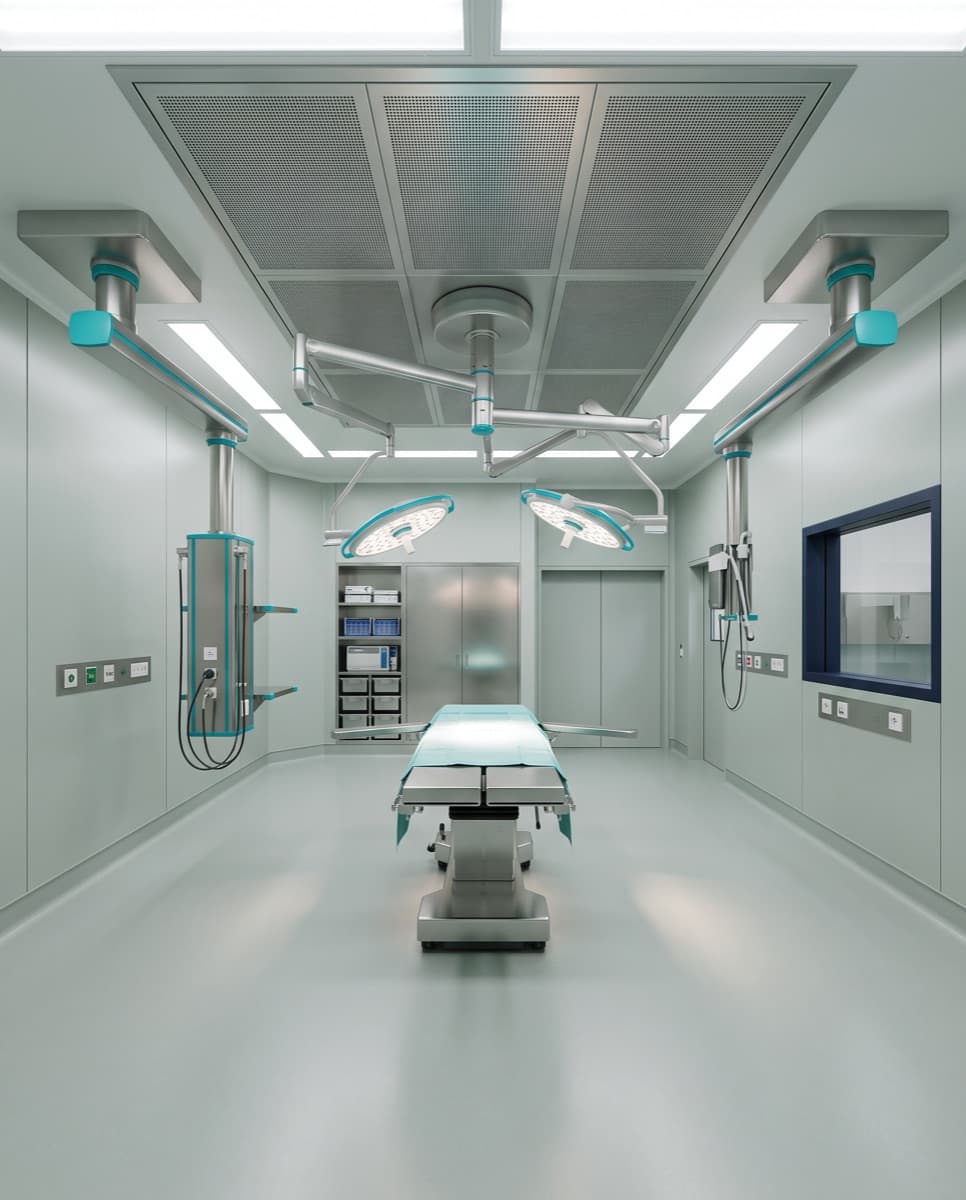 Quirófano equipado con lámpara cialítica, brazos de servicio en techo y acabados sanitarios continuos.